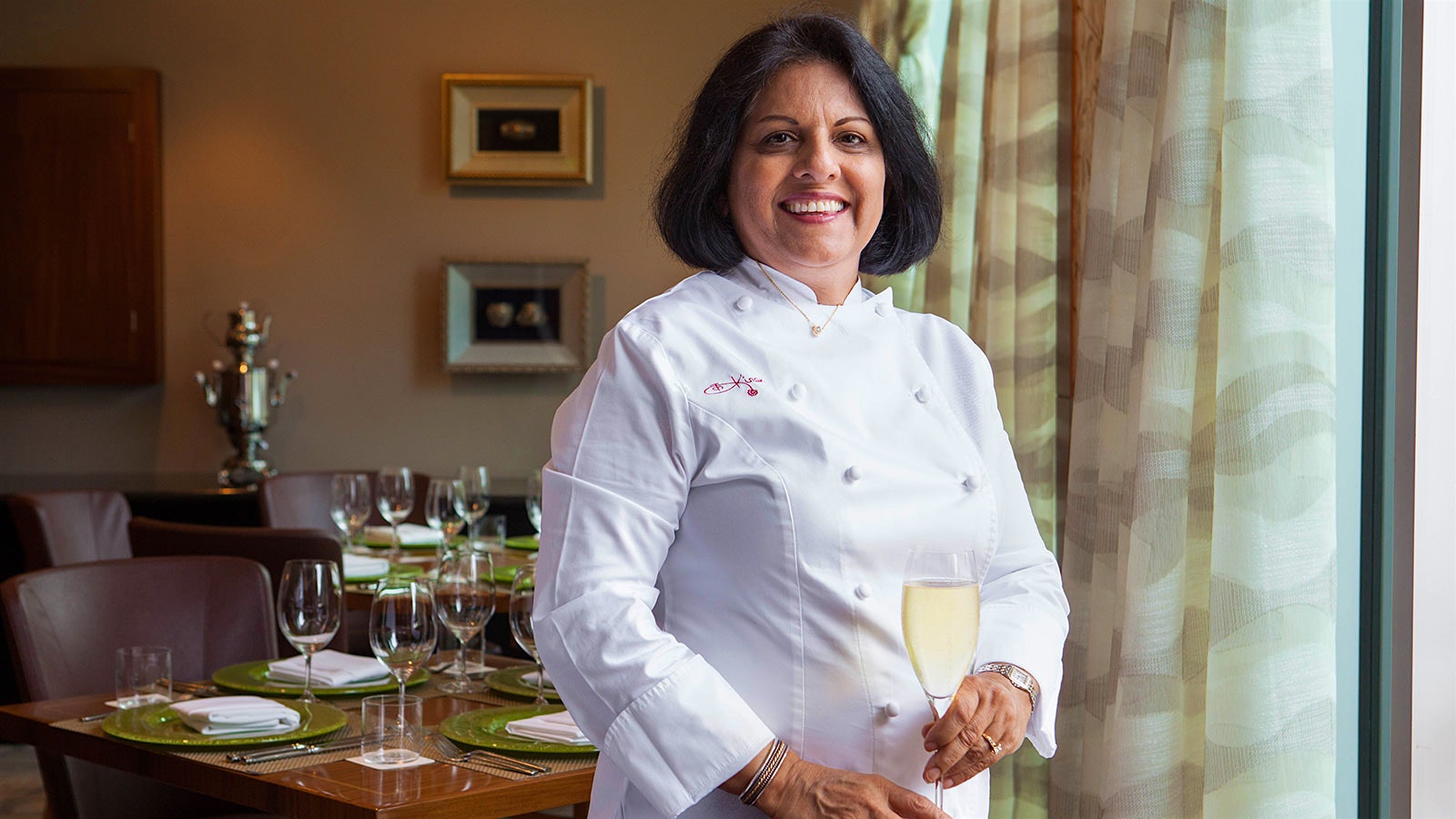Chef Kiran Verma with a glass of Champagne in her restaurant, Kiran's
